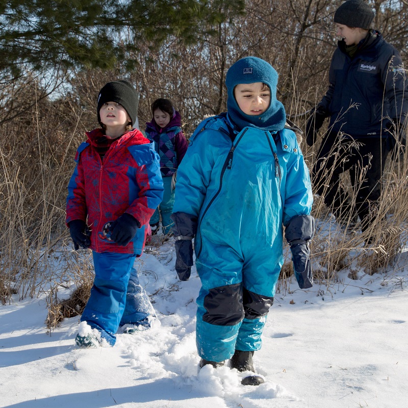 children walking through snow at Kortright Centre winter day camp