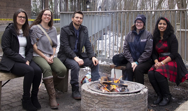 TRCA staff members gather by fire at annual pancake breakfast