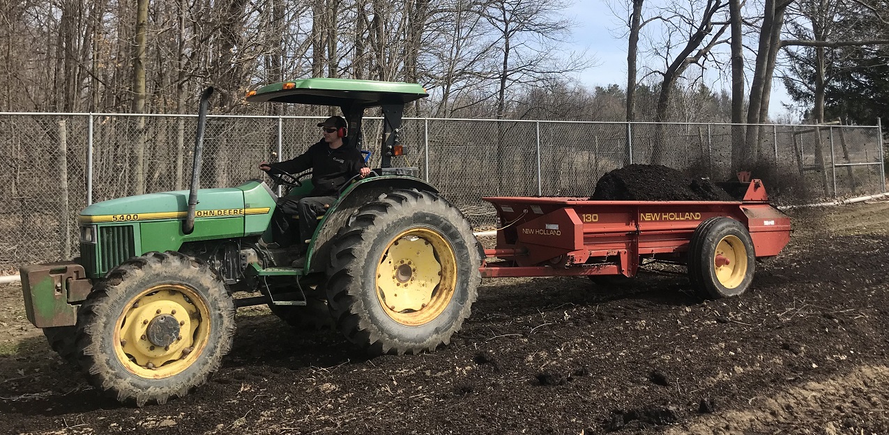 TRCA nursery team member Tyler Cathcart applying aged pine bark fines